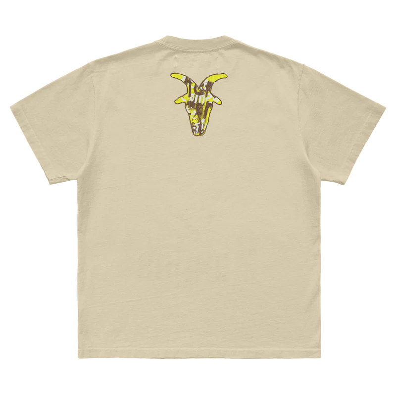 Tan t-shirt featuring a mask goat silhouette graphic with "Here Comes the Pain 25th Anniversary" on front and a goat silhouette on back